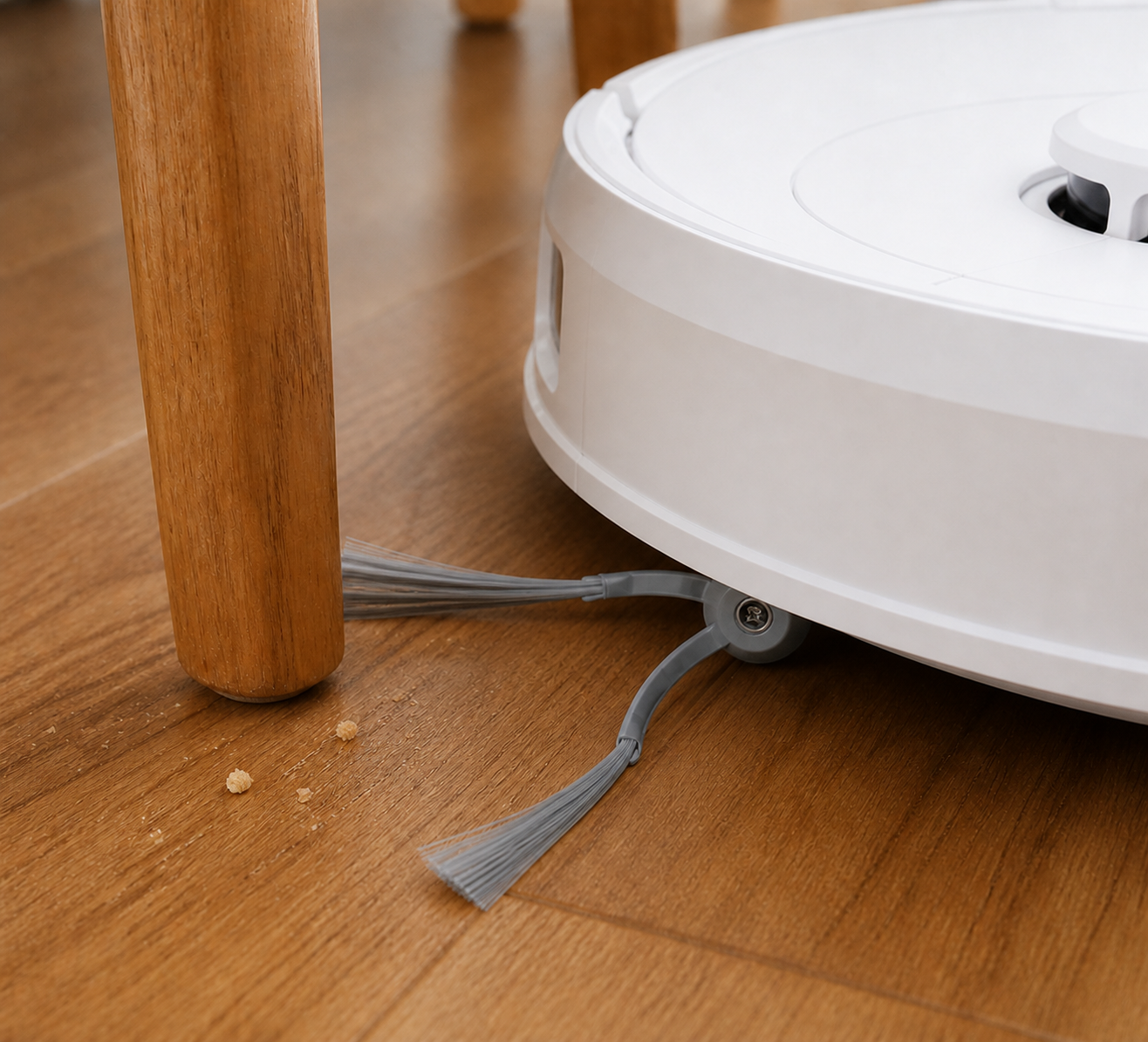 برس کناری خاکستری دو بازویی Roborock Qrevo C نصب‌شده زیر ربات کنار پایه چوبی صندلی