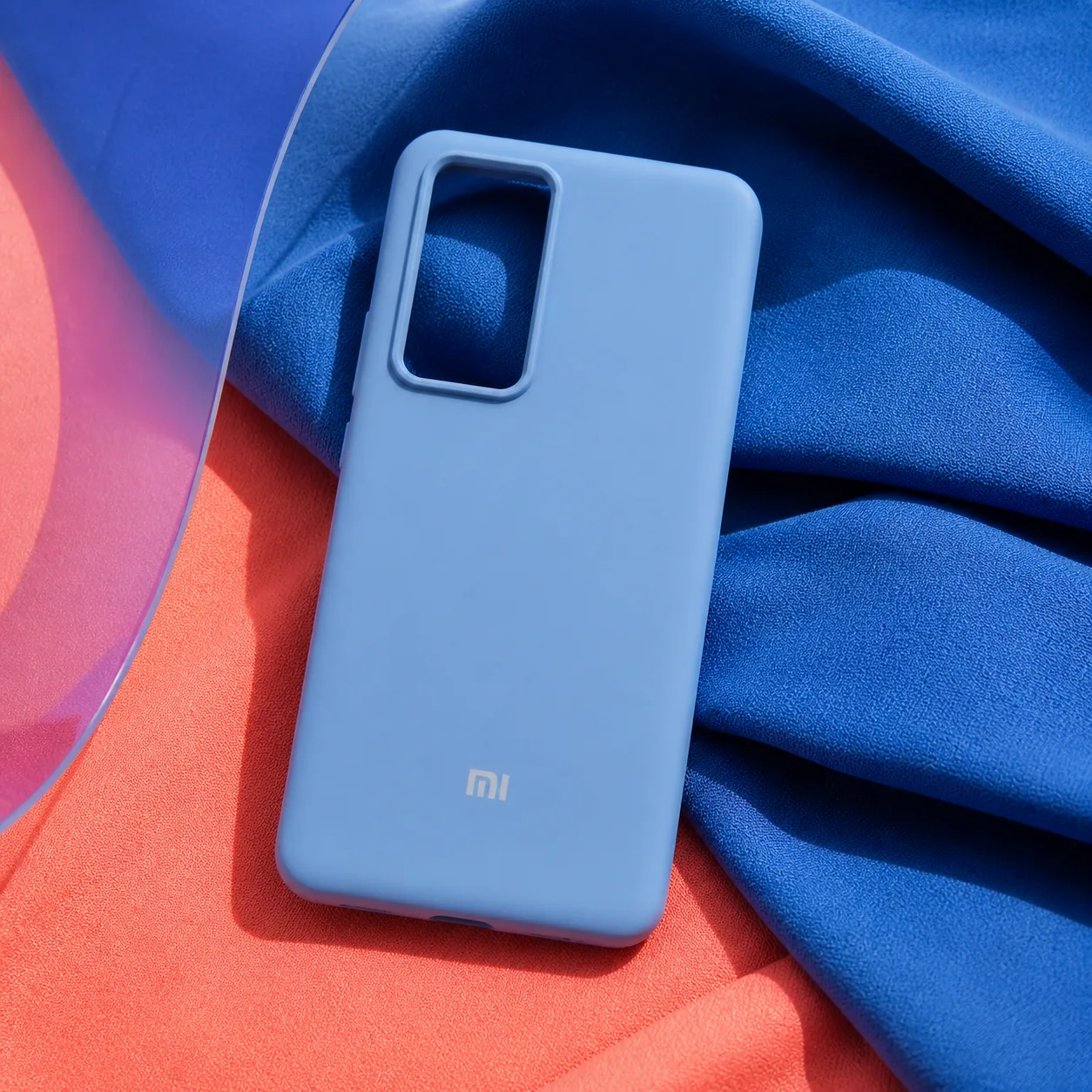 کاور سیلیکونی Xiaomi 12T در ترکیب رنگی ادیتوریال کاور سیلیکونی آبی آسمانی Xiaomi 12T روی پارچه آبی و مرجانی