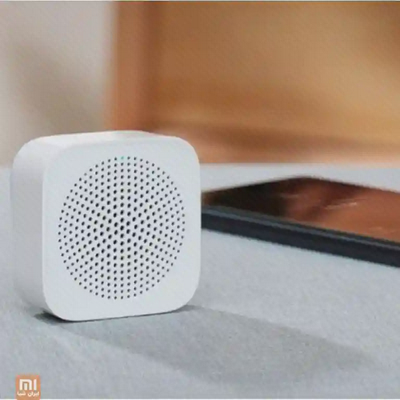 اسپیکر شیائومی Xiaoai XMYX07YM روی سطح پارچه‌ای کنار میز