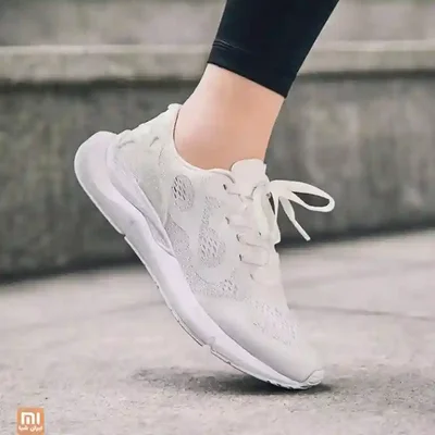 کفش دویدن سفید Xiaomi Codoon 10K روی پا پوشیدن کفش سفید شیائومی Codoon 10K Running هنگام قدمبرداشتن