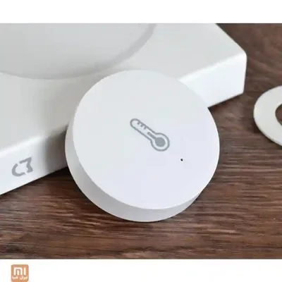 چیدمان سنسور محیطی Xiaomi کنار هاب سنسور دما و رطوبت شیائومی روی میز کنار هاب هوشمند سفید