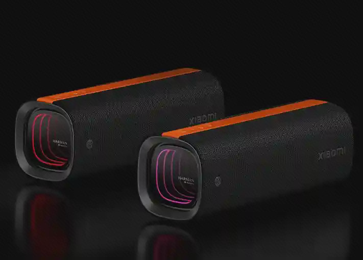 دو اسپیکر Xiaomi Sound Party با نور رنگی دو اسپیکر Xiaomi Sound Party کنار هم با نور قرمز و بنفش در قابهای کناری روی زمینه تیره