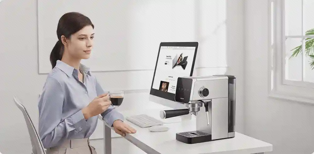 استفاده از اسپرسوساز Xiaomi CME003 در کنار میز کار زن در حال نوشیدن قهوه کنار اسپرسوساز شیائومی CME003 روی میز