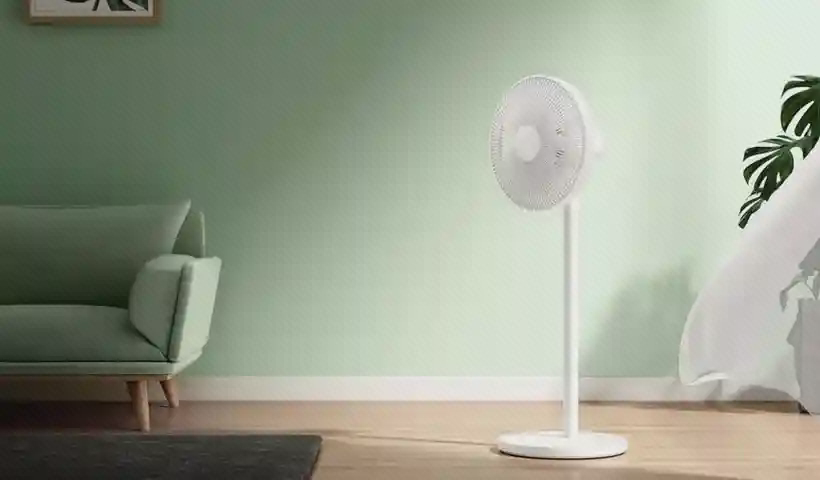 نمای پنکه Mijia Standing Fan 1X در اتاق پنکه سفید میجیا Standing Fan 1X کنار مبل در اتاق با دیوار سبز