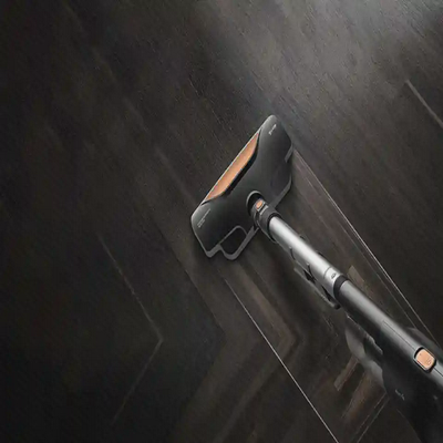 سری کف Deerma DX600 در حال جاروکردن سطح چوبی تیره
