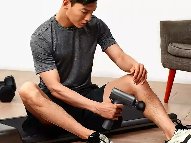 ماساژور تفنگی شیائومی Mijia Electric Fascia Gun Massager MJJMQ01-ZJ در حال ماساژ دادن عضله پا