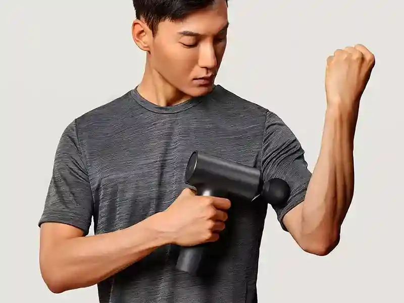 ماساژور تفنگی شیائومی Mijia Electric Fascia Gun Massager MJJMQ01-ZJ در حال ماساژ دادن عضله دست