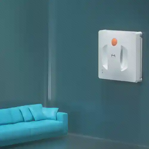 شیشهشوی Hutt W600 در نمای اتاق شیشهشوی سفید Hutt W600 روی شیشه بلند مقابل مبل آبی در فضای اتاق