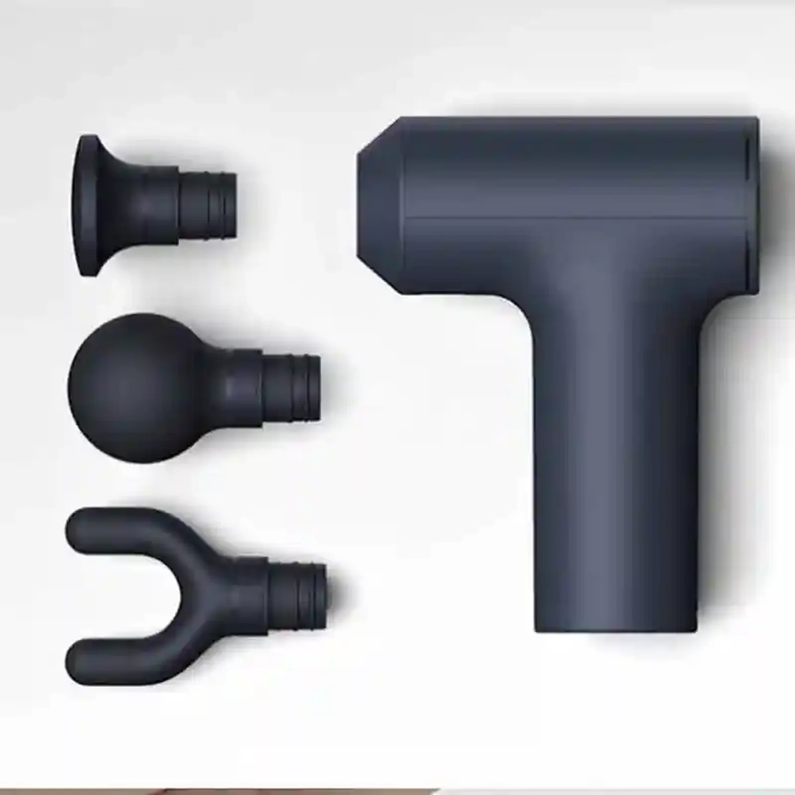 سریهای قابل تعویض ماساژور مینی شیائومی XMFG-M352 ماساژور شیائومی XMFG-M352 سرمهای کنار سه سری تخت، توپی و دوشاخه روی زمینه روشن