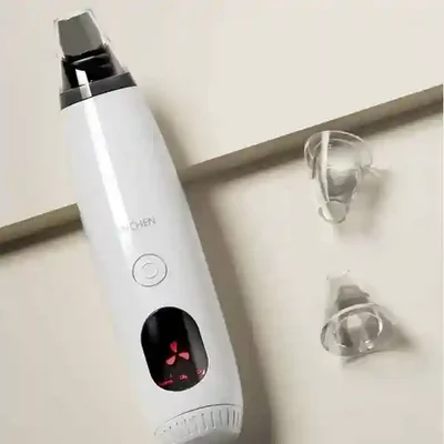 میکرودرم شیائومی مدل Enchen EB1001 سفید کنار دو سری شفاف جداشده روی سطح کرم