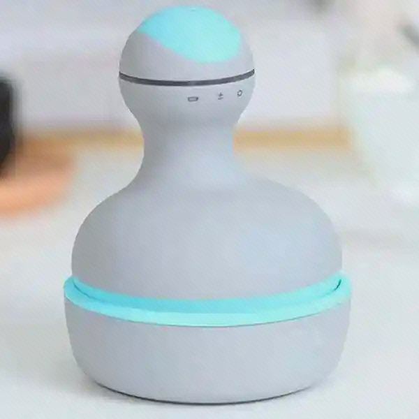 ماساژور سر Mini M2 روشن روی پایه با نور آبی دور بدنه