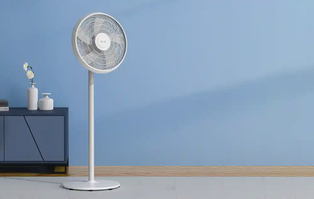 نمای پنکه ایستاده Deerma DEM-FD15W پنکه ایستاده سفید Deerma DEM-FD15W کنار میز مقابل دیوار آبی