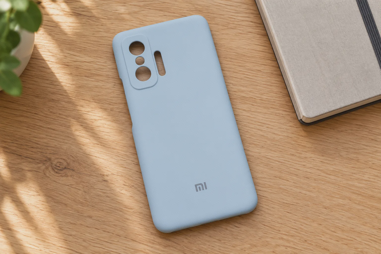 تصویرسازی کاور آبی کم‌رنگ Xiaomi 11T روی میز چوبی، با نمایش برش‌های دوربین