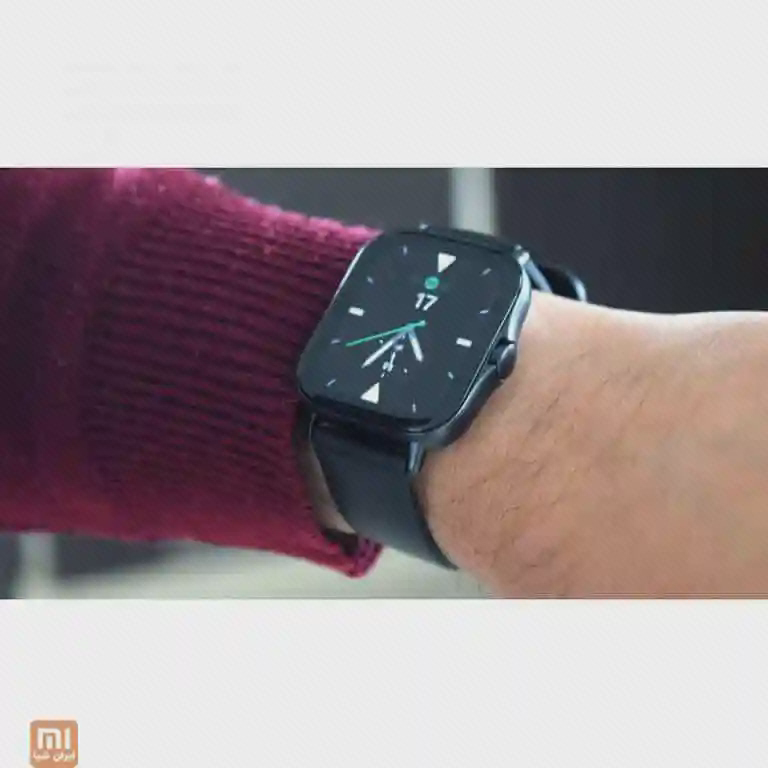 ساعت Amazfit GTS 2e با بند تیره روی مچ دست کنار آستین زرشکی