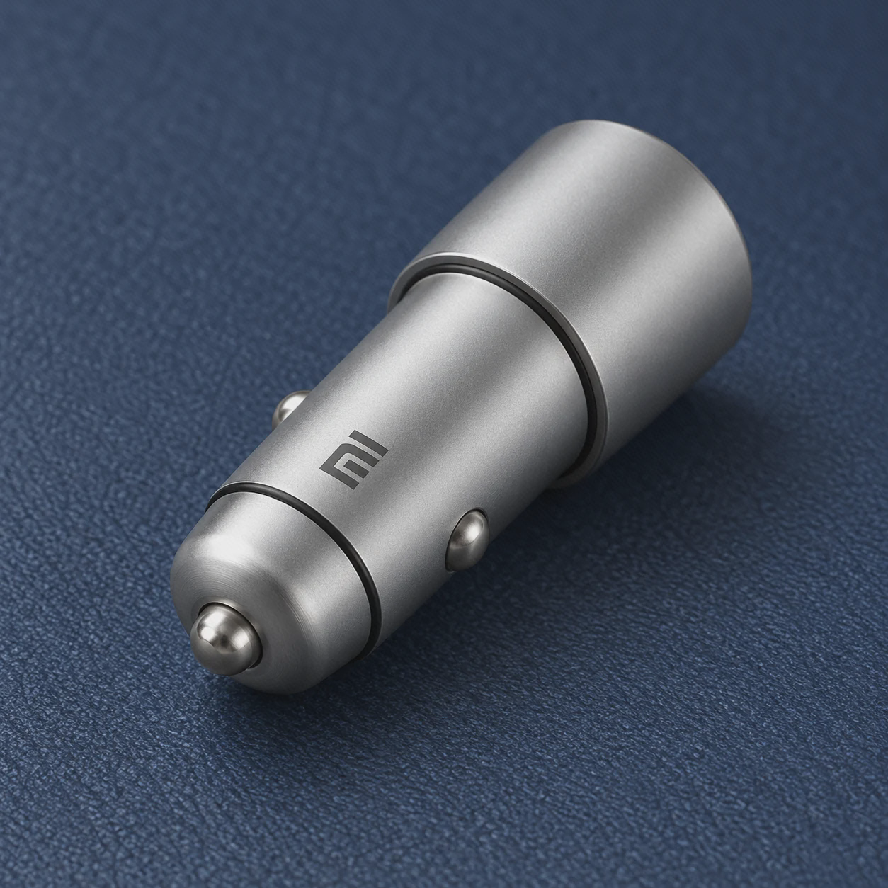 نمای بدنه و اتصال فندکی شارژر CC02CZM بدنه فلزی نقرهای و نوک اتصال شارژر فندکی شیائومی CC02CZM روی پارچه آبی