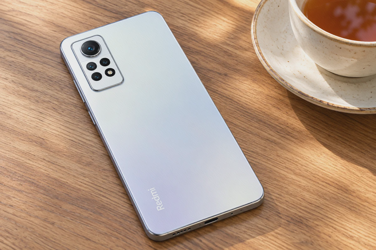 بدنهٔ سفید و چهار دوربین Redmi Note 12 Pro 4G روی میز چوبی