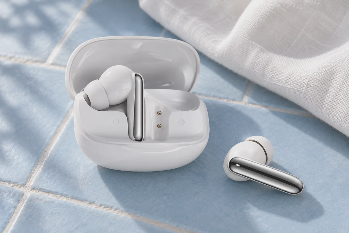 کیس سفید باز QCY MeloBuds N50 با یک ایرباد داخل و دیگری کنار کیس روی کاشی آبی
