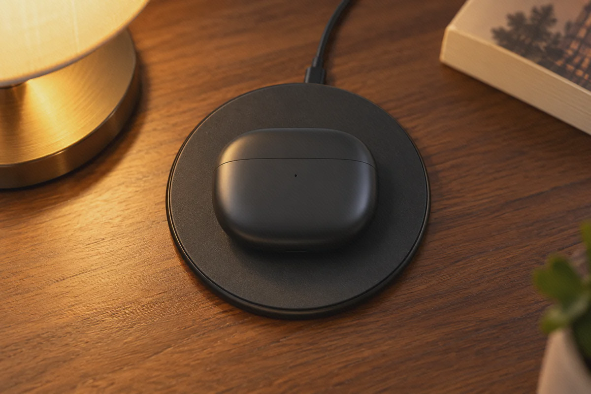 کیس مشکی بسته Xiaomi Buds 3 با جلوی بدنه رو به بالا روی پایه گرد شارژ بی‌سیم