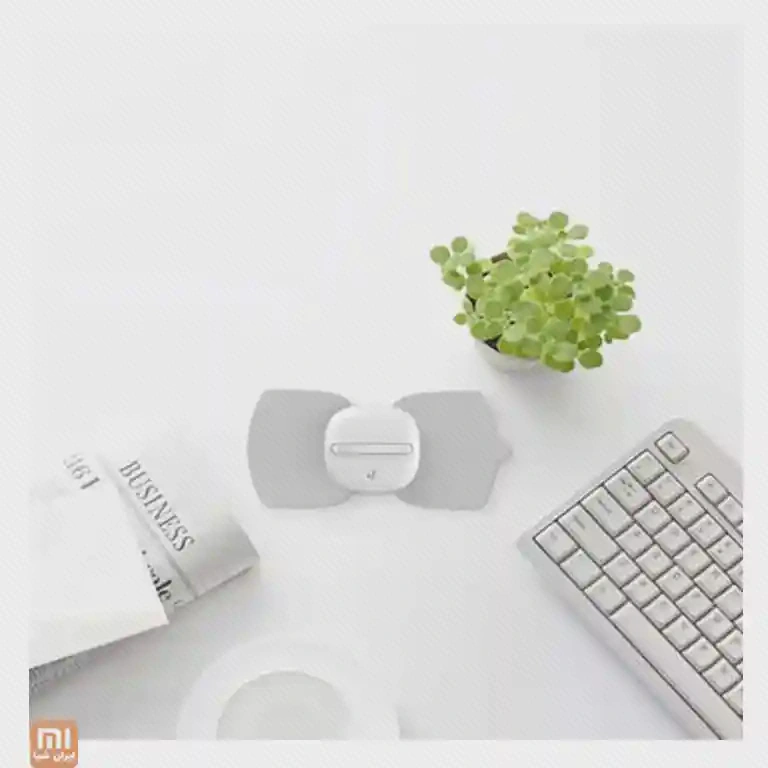 اندازه و چیدمان رومیزی LeFan Magic Touch پد LeFan Magic Touch روی میز سفید کنار صفحهکلید، کتاب و گلدان کوچک