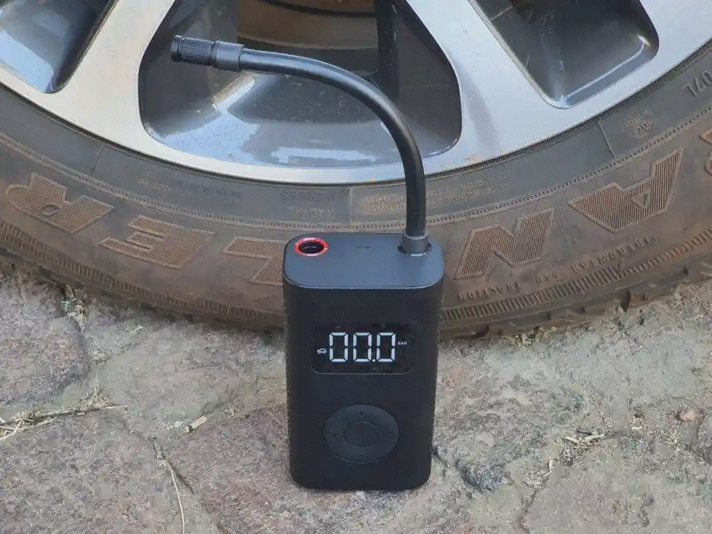 اتصال شیلنگ MJCQB02QJ به تایر خودرو پمپ شارژی شیائومی روی زمین کنار تایر خودرو با شیلنگ پیچی متصل به والو