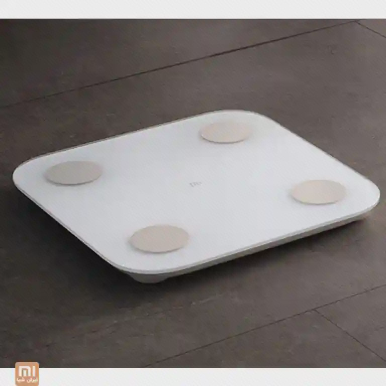 بدنهٔ تخت ترازوی Mi Body Composition Scale 2 نمای مایل ترازوی سفید Mi Body Composition Scale 2 روی کف با چهار الکترود گرد