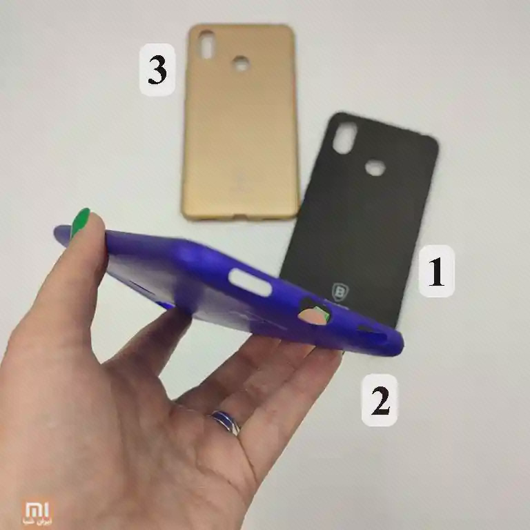 قاب آبی Mi Max 3 در نمای بسیار مایل در دست، با قاب‌های طلایی‌رنگ و مشکی در پس‌زمینه
