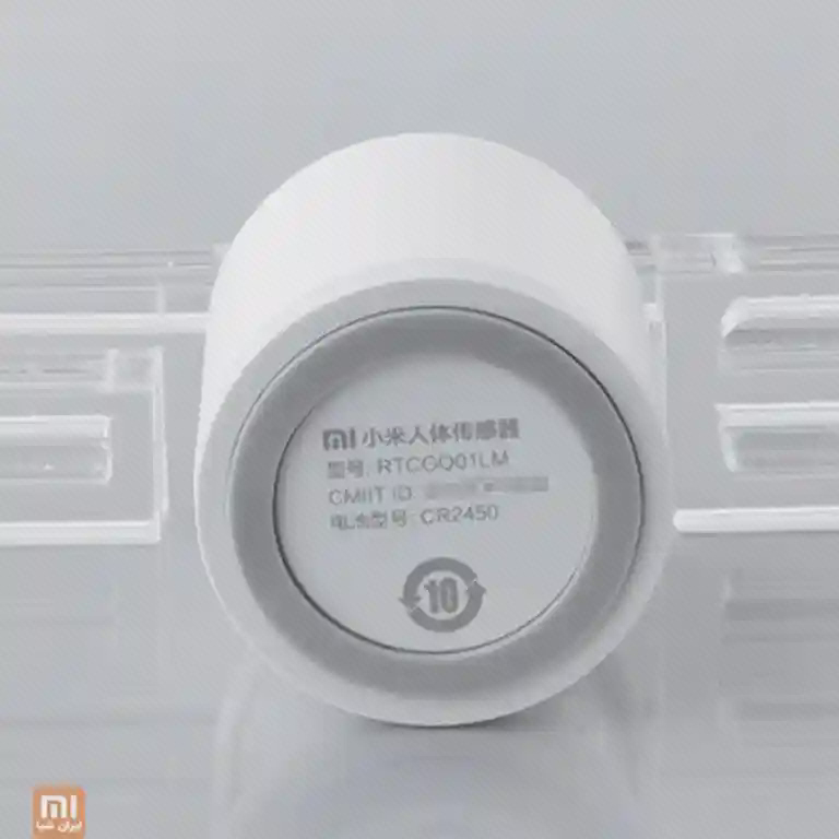 برچسب مدل و باتری سنسور حرکت زیر سنسور Mi Motion Sensor با نوشتهٔ RTCGQ01LM و CR2450 روی درپوش گرد