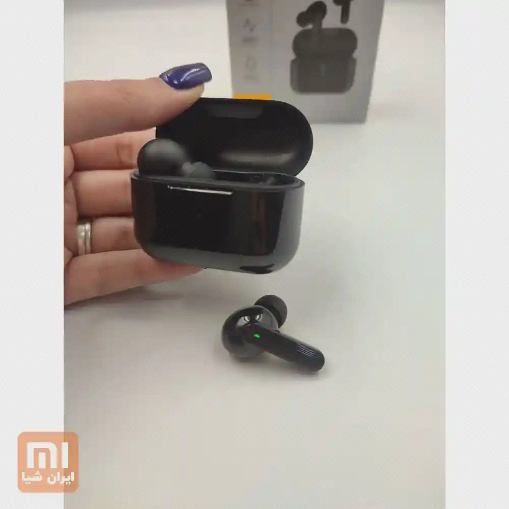 کیس باز QCY T10 Pro در دست و ایرباد مشکی کنار آن با جعبه در پس‌زمینه