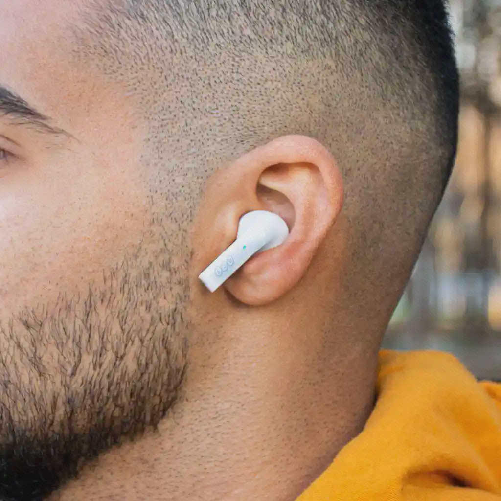 گوشی سفید QCY T18 داخل گوش یک فرد در نمای نزدیک
