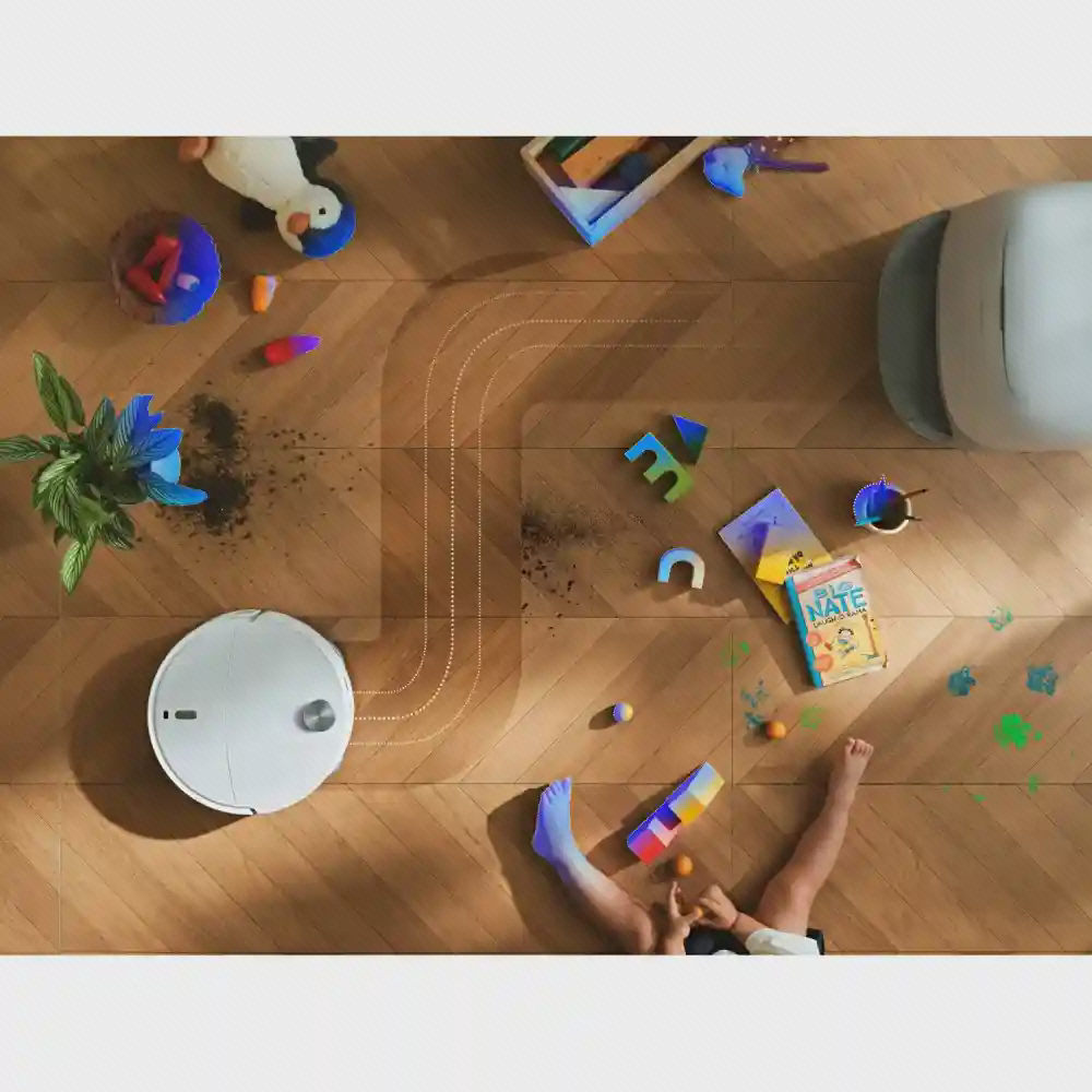 ربات سفید Curv 2 ProX میان اسباب‌بازی‌ها با مسیر نقطه‌چین روی کف