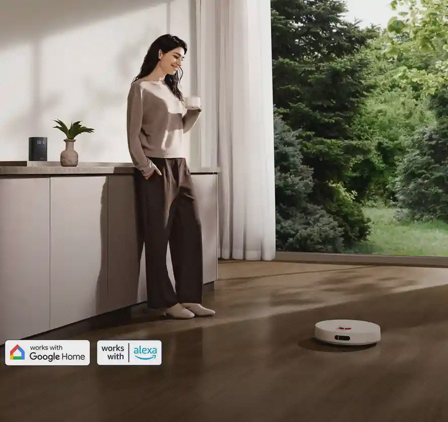 جارو سفید H40 روی کف اتاق کنار کاربر با نشان‌های Google Home وAlexa