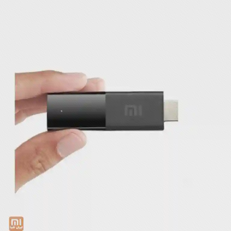 اندازهٔ جمعوجور دانگل Mi TV Stick دانگل Mi TV Stick میان انگشتان با کانکتور HDMI در انتهای بدنه
