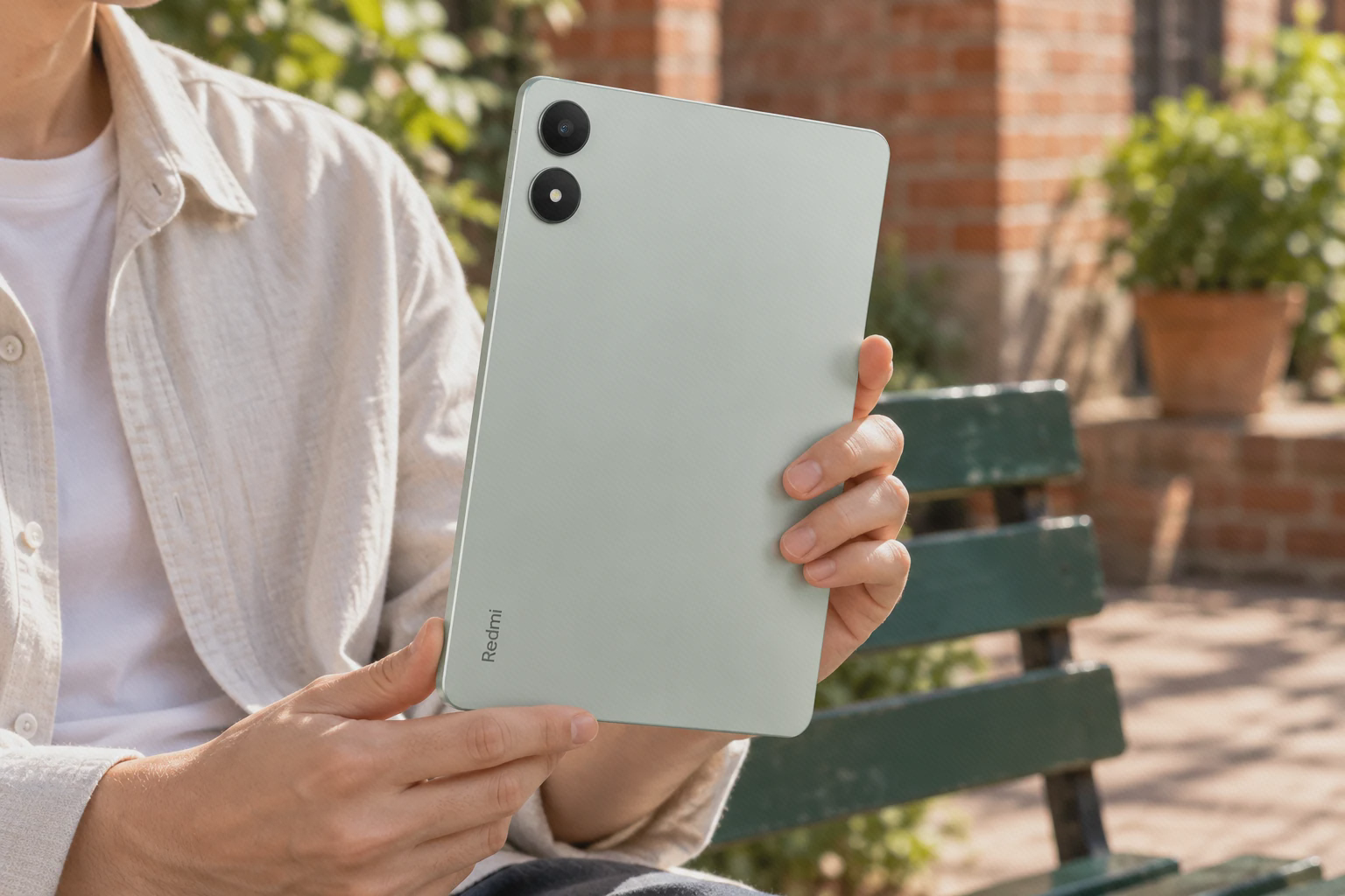 آرایش حلقههای دوربین و فلاش ردمی پد پرو سبز روشن تبلت سبز روشن Redmi Pad Pro از پشت در حیاط؛ حلقهٔ لنز بالا و حلقهٔ فلاش پایین آن دیده میشوند