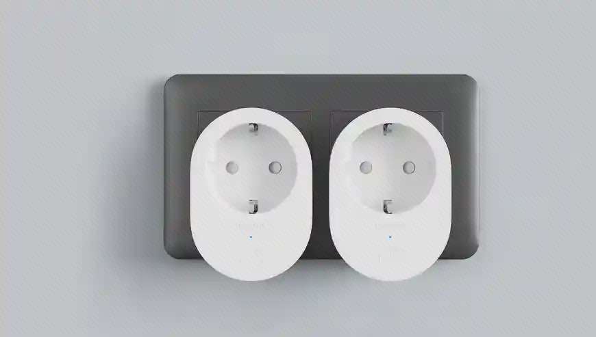 دو پریز هوشمند سفید Xiaomi Smart Plug 2 روی یک صفحه دوخانه در نمای روبه‌رو